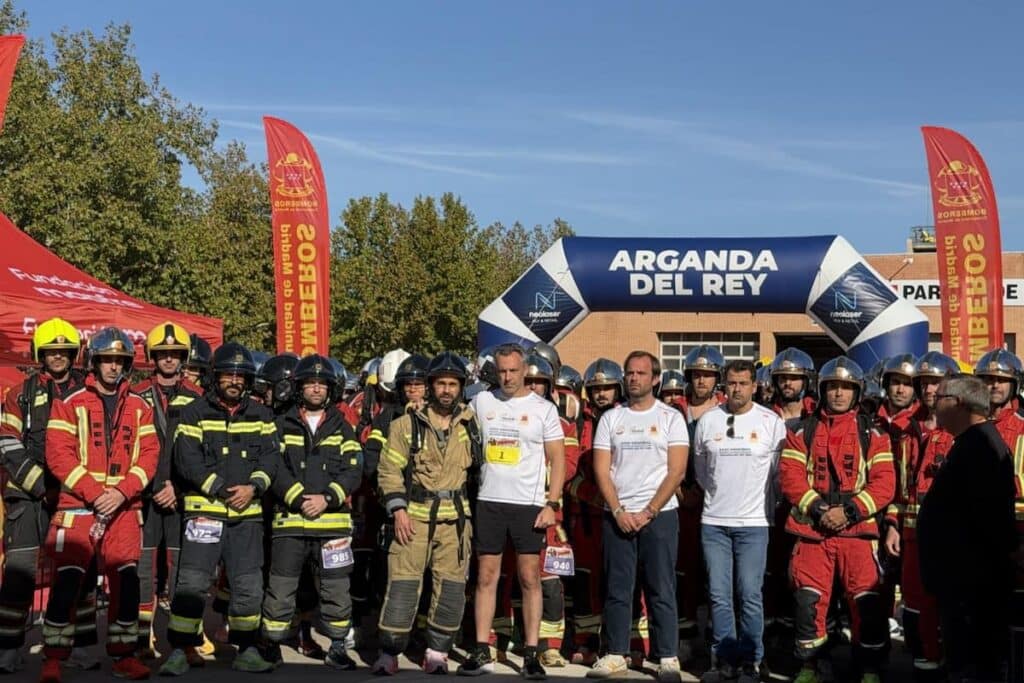 El consejero Carlos Novillo y el alcalde de Arganda, Alberto Escribano, posan con los bomberos que han participado en la carrera popular el Memorial de Bomberos celebrada en Arganda